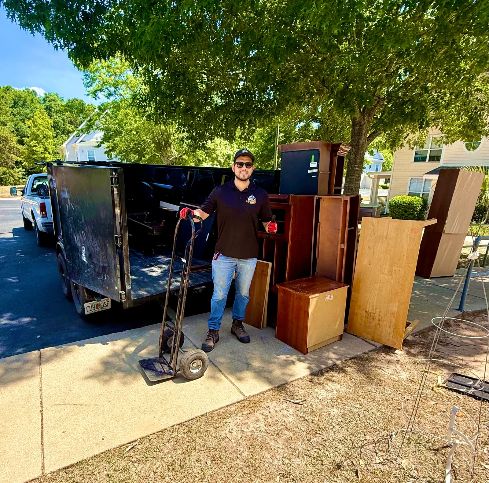 Tally Junk Removal crew loading a sofa and other bulky furniture into a dump trailer in Tallahassee