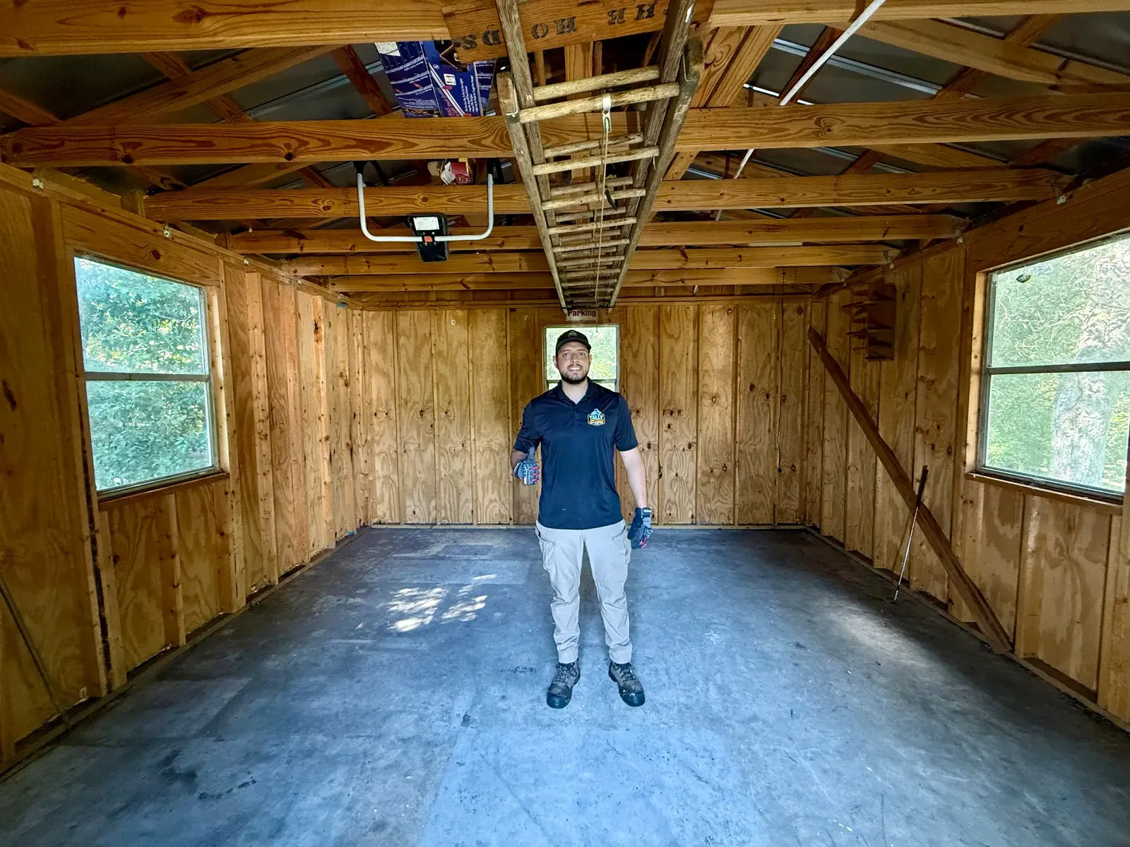 Owner in the same emptied wooden shed room with the floor visible