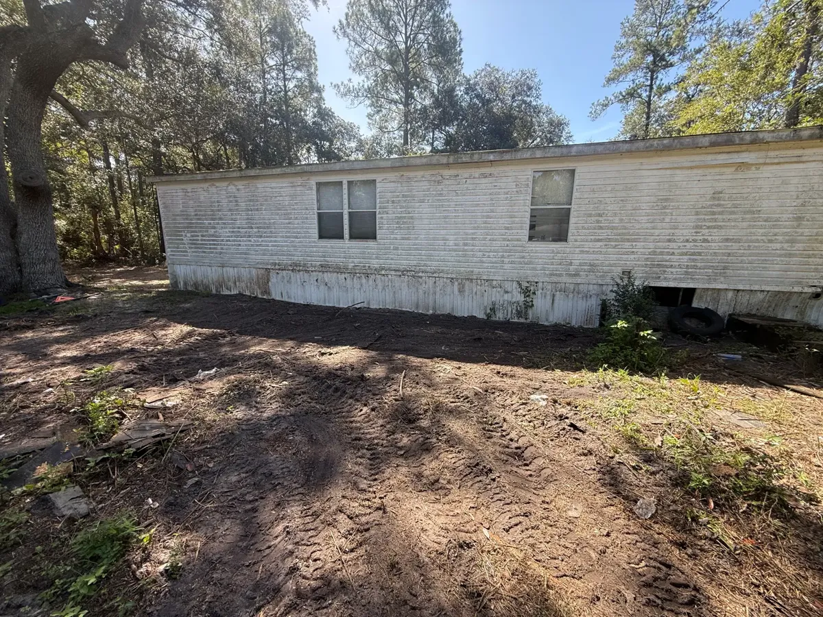 Bare ground beside the home after the deck was demolished and hauled away