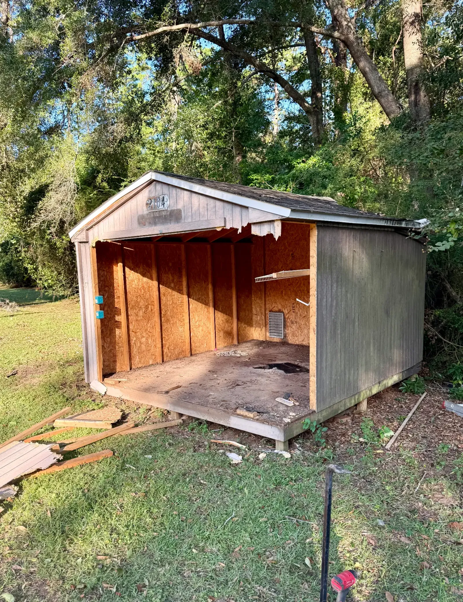 Same gabled shed partially dismantled with its front wall opened